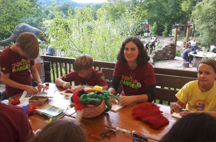 Junior Ranger und eine Betreuerin beim Basteln mit Naturmaterialien