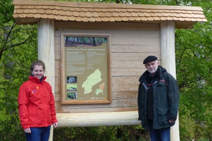 Das Bild zeigt zwei Personen an einem Infoschild über die Kernzonen des Biosphärenreservats Pfälzerwald.