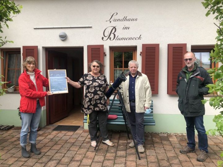 Anna Prim überreicht den Gastgebern vor dem Landhaus Blumeneck das Zertifikat. Bürgermeister Ralf Weber steht rechts.