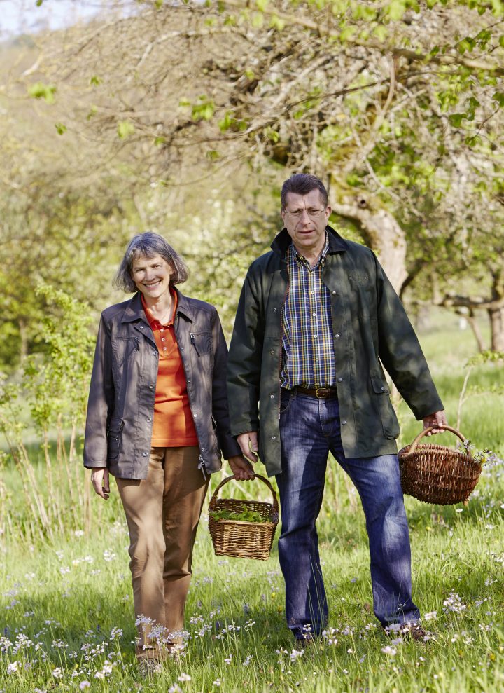 Das Bild zeigt Ursula und Johannes Schauer mit Körben in der Hand auf einer Wiese